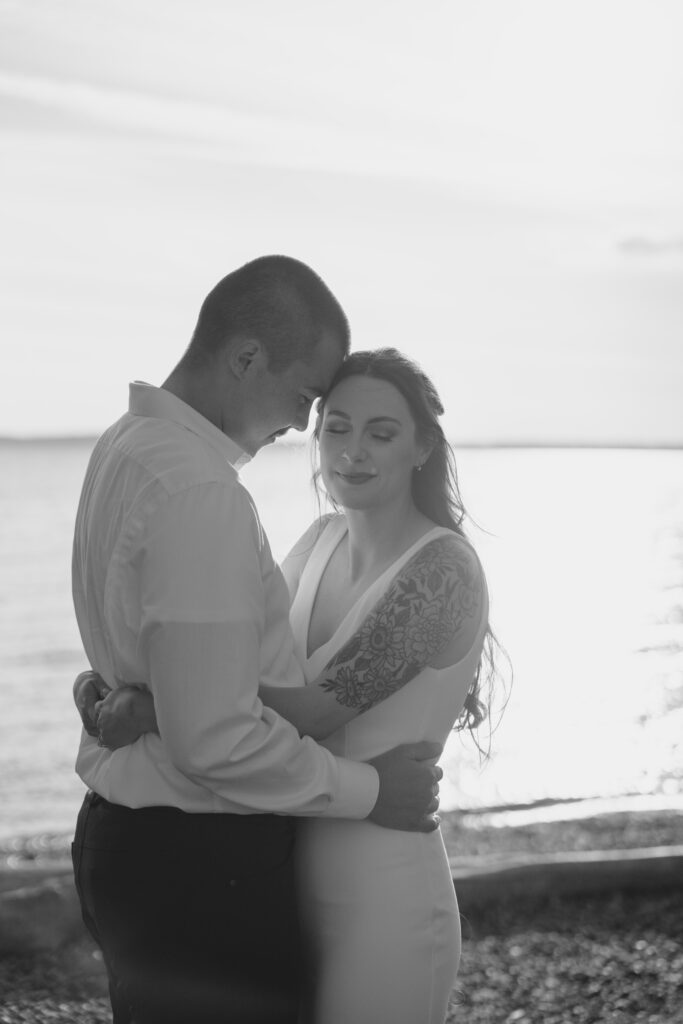 bride and groom hug on beach during Bellingham engagement session