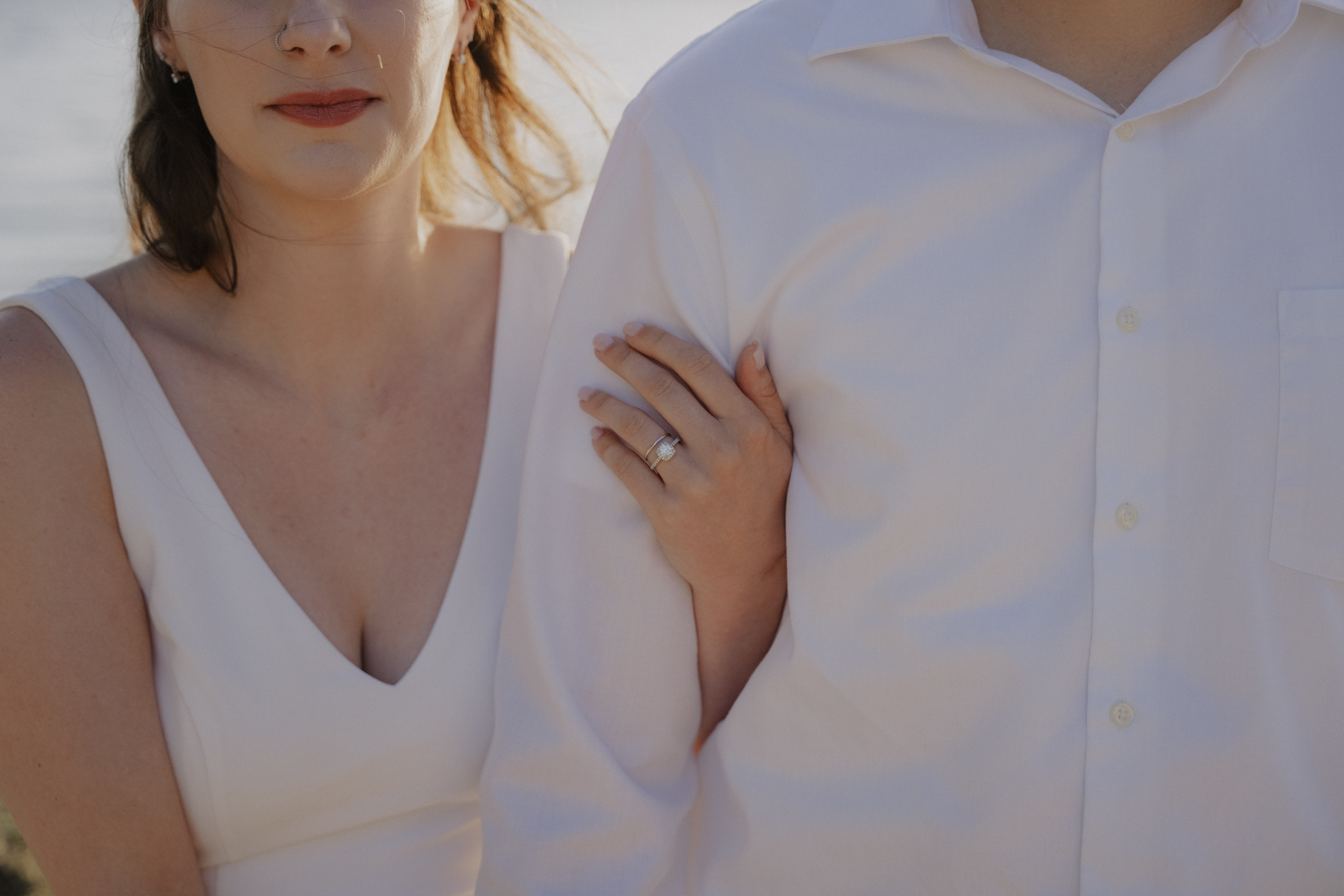 hand with diamond ring holds onto grooms arm during Bellingham engagement shoot