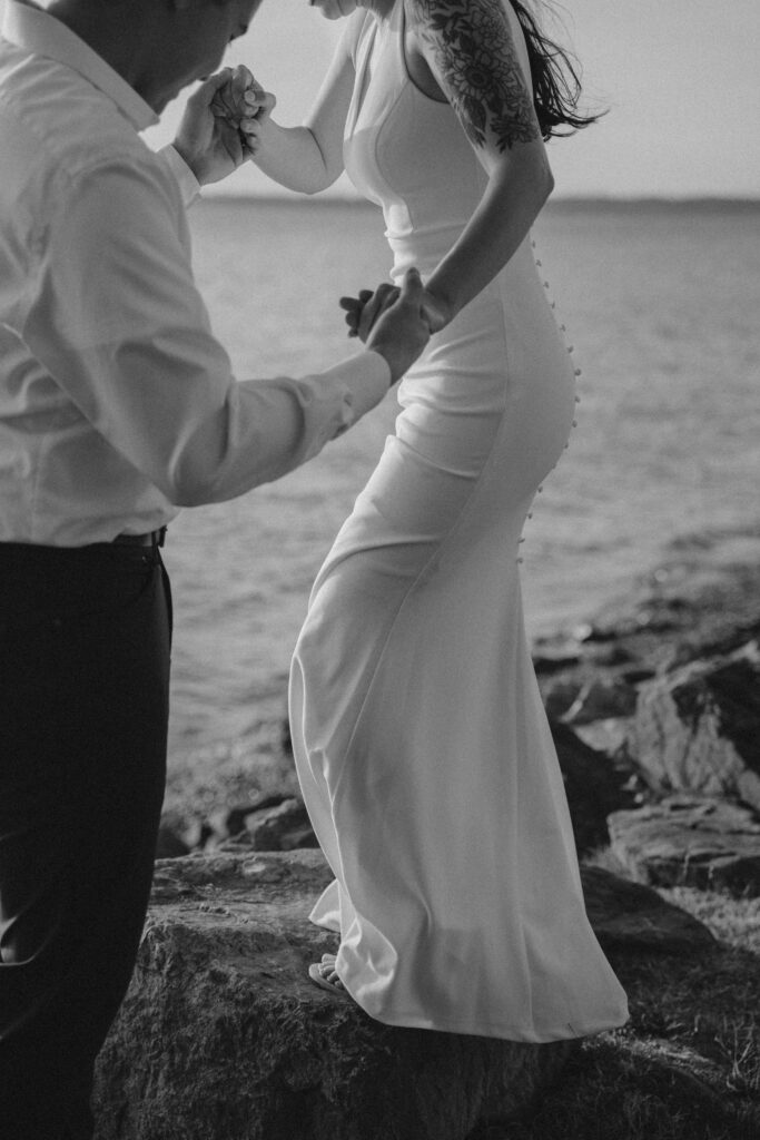 groom and bride stand on ocean rocks staring into ocean during Bellingham engagement shoot