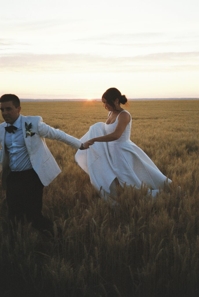 bride and groom walk into a wheat field at Abeja winery wedding