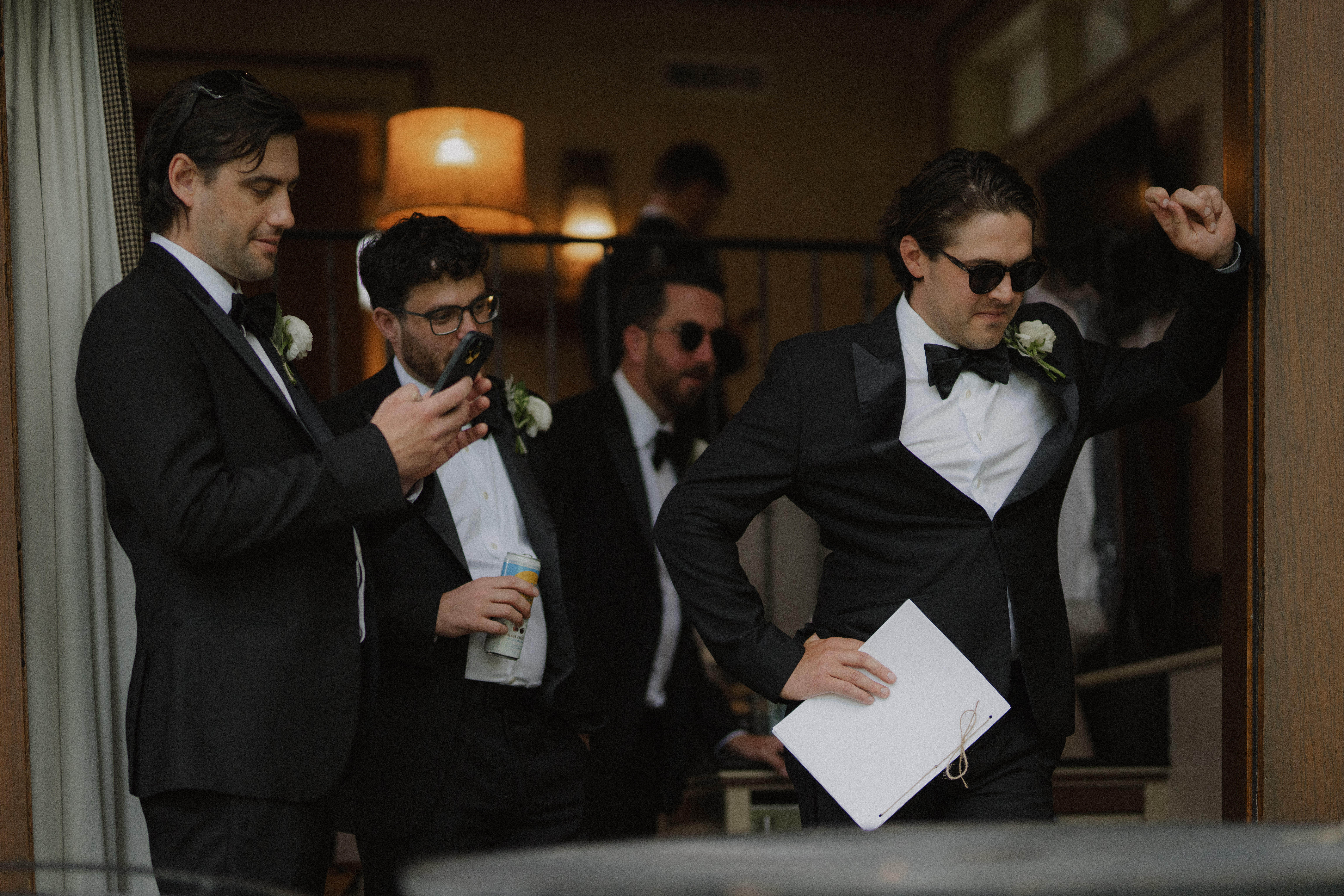 groomsmen watch groom get dressed
