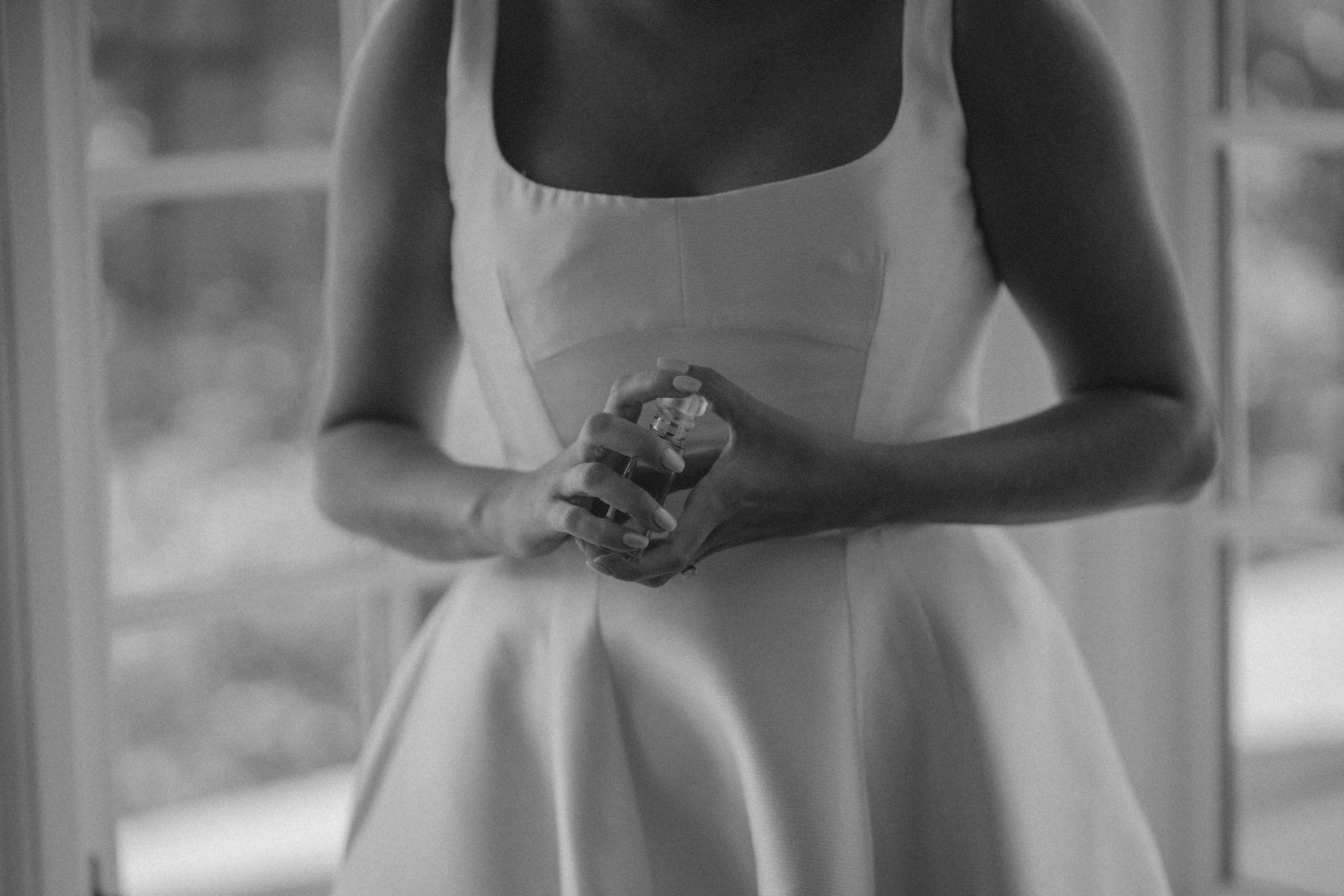 bride holds perfume against her chest