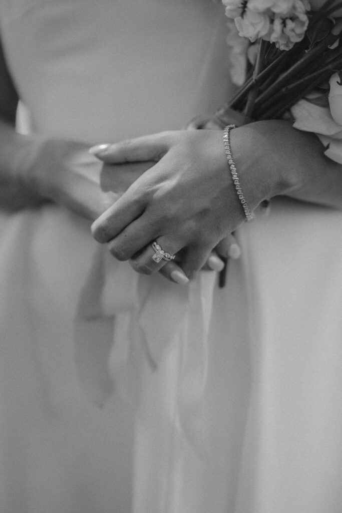 brides hands crossed on her dress