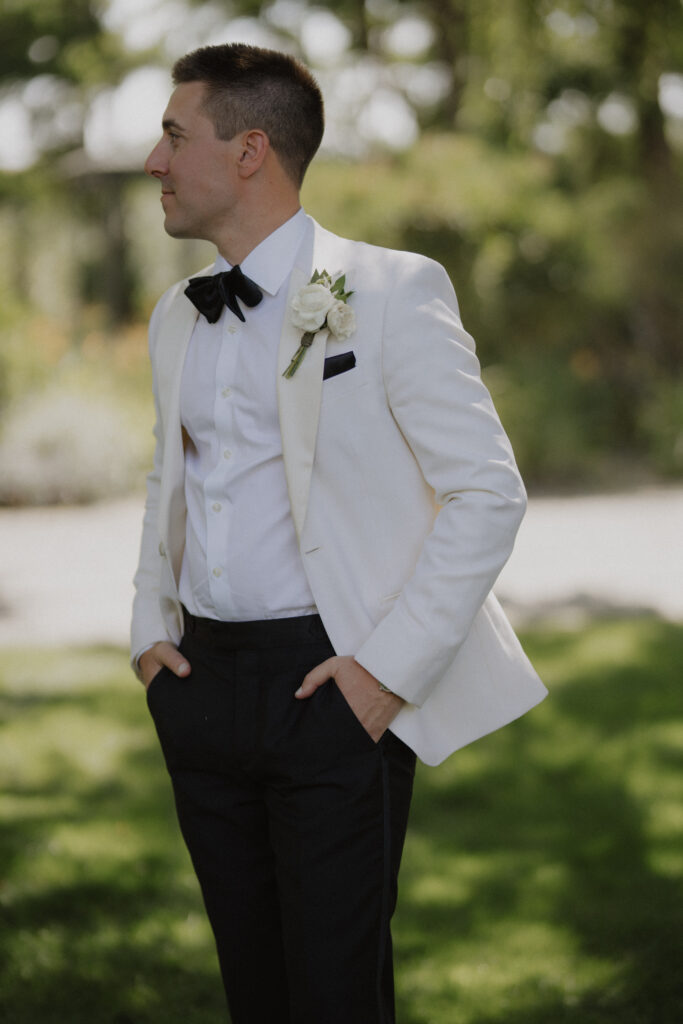 groom puts hands in pockets and looks into the distance at Abeja winery wedding