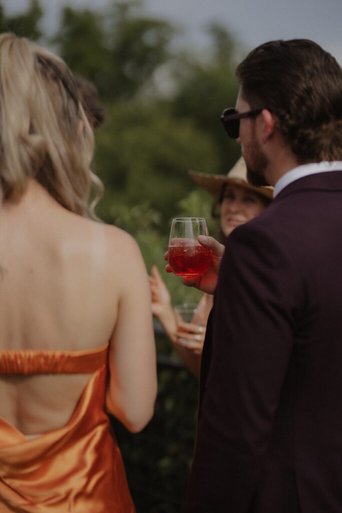 wedding guests hold red wine