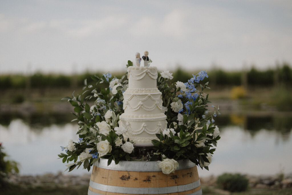 wedding cake surrounded by blue and white florals
