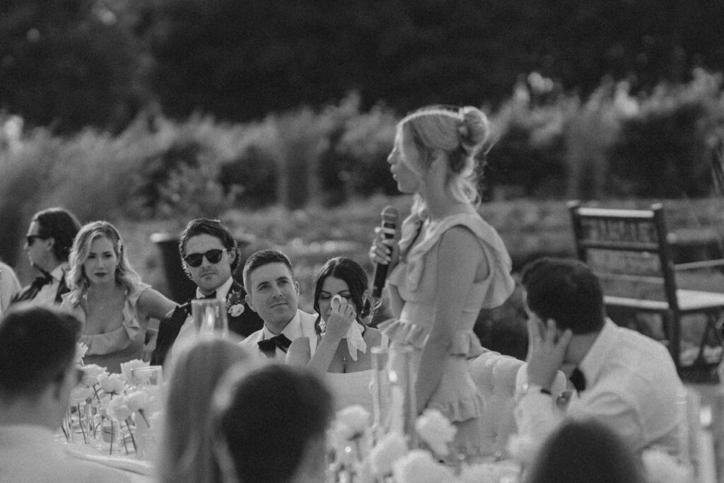 bridesmaid stands in front of guests giving a speech