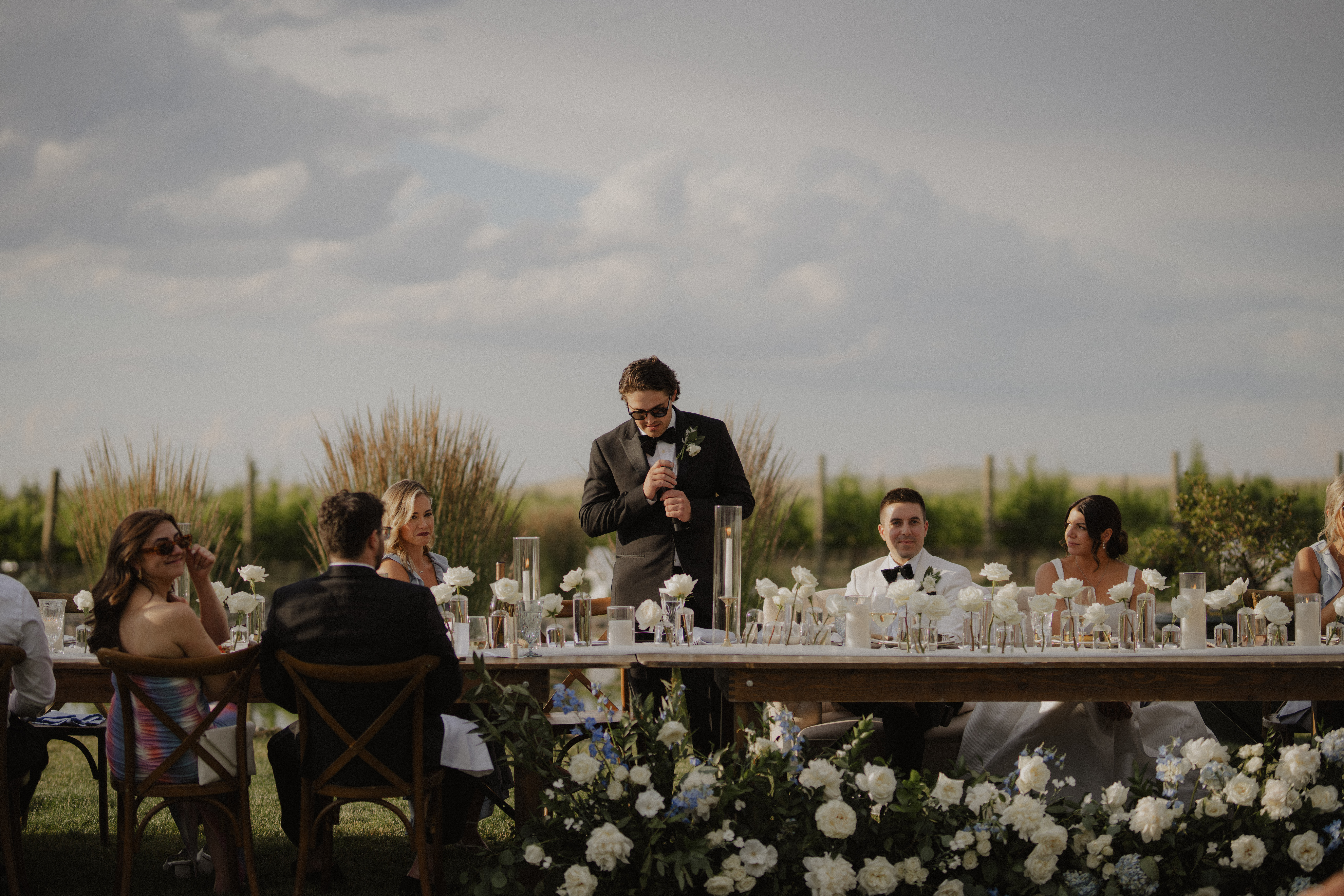 groomsman stands in front of guests giving speech